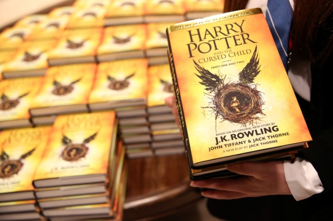 A store assistant holds copies of the book of the play of Harry Potter and the Cursed Child parts One and Two at a bookstore in London